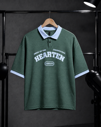A dark green short-sleeve polo shirt with a light blue collar and sleeve cuffs, featuring 'HEARTEN' and 'ARMANI' printed in white on the chest, hanging on a wooden hanger against a dark studio backdrop.