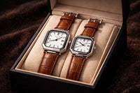 Pair of brown leather watches in a box on a dark background