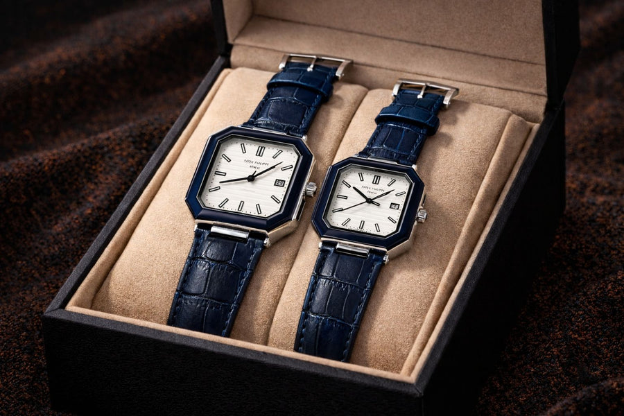 Two blue watches in a beige box on a dark background