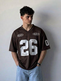 Person wearing a brown sports jersey with white text and numbers against a plain background