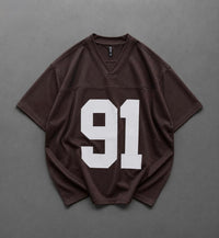 A dark brown v-neck athletic jersey with the number 91 printed in large white block letters on the front, laid flat on a gray background.